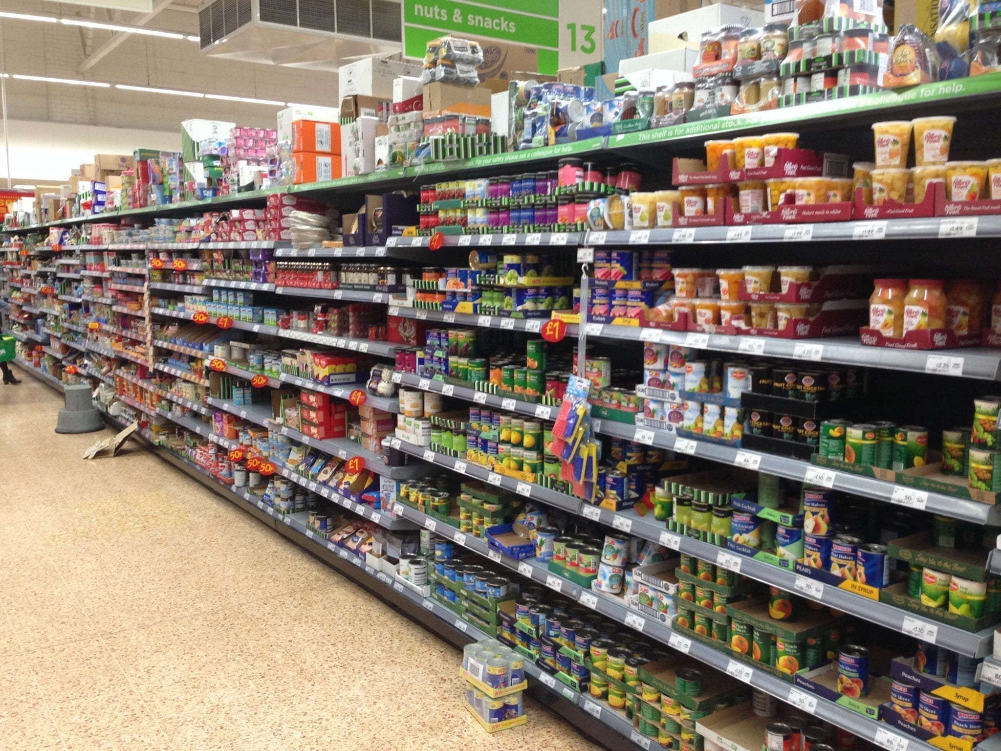 A full supermarket shelf lined with many tins