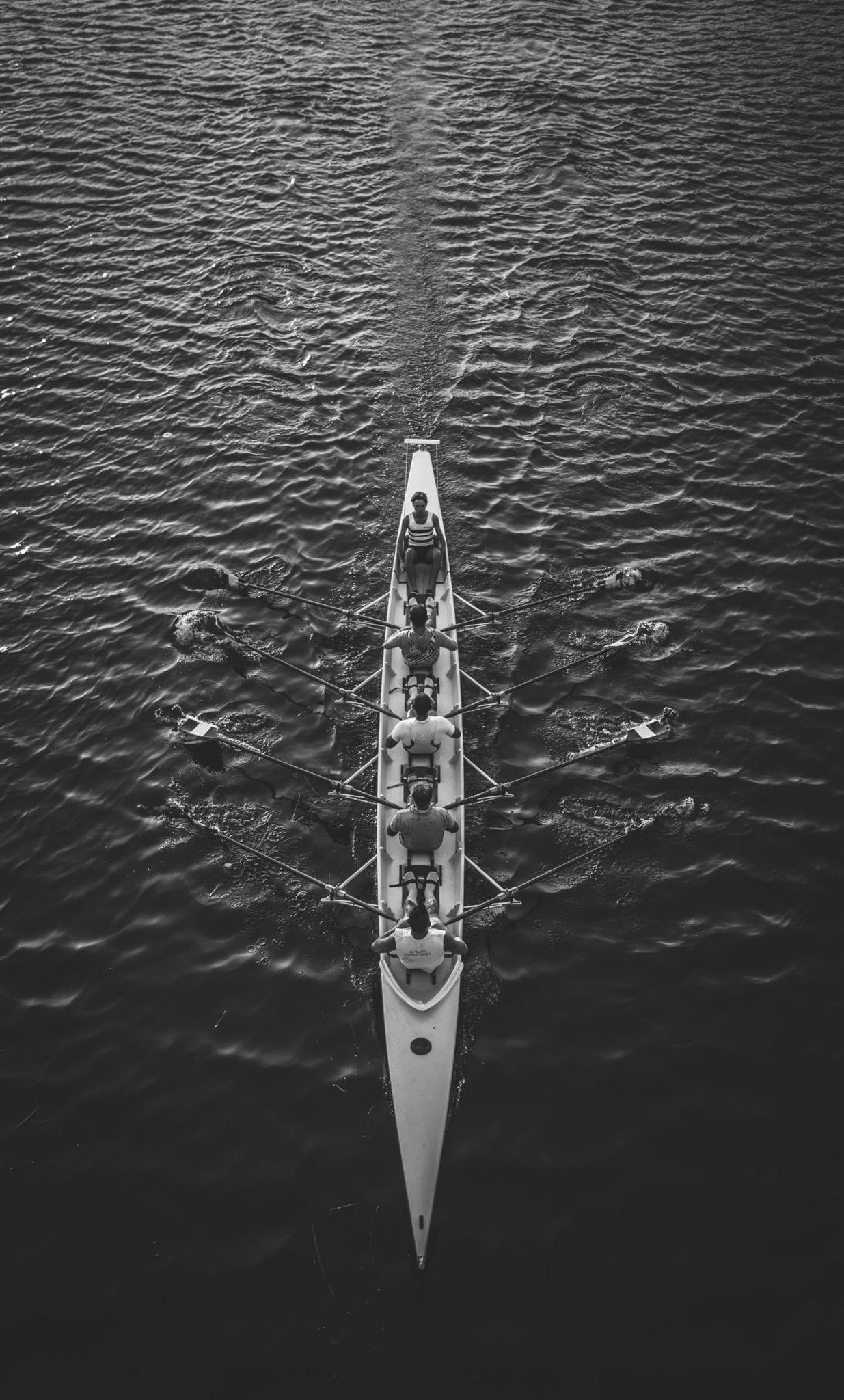 Top view of a rowing team in a rowboat in the middle of the sea 