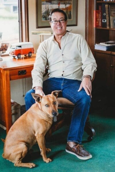 Midshot of George Troy with his dog next to him