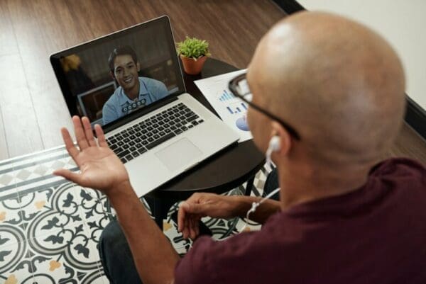 Male coworker influencing through 16 inch screen during online business meeting