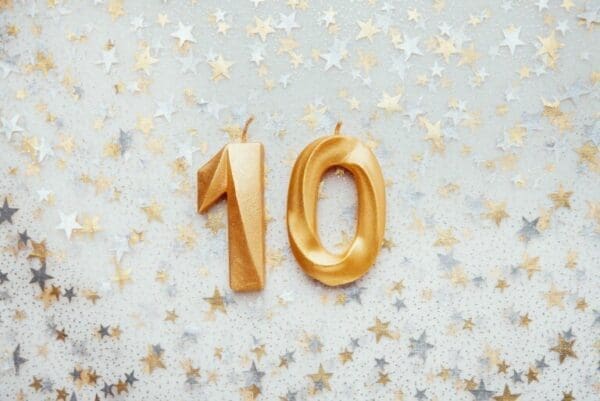 Number 10 ten golden celebration birthday candle on Festive Background