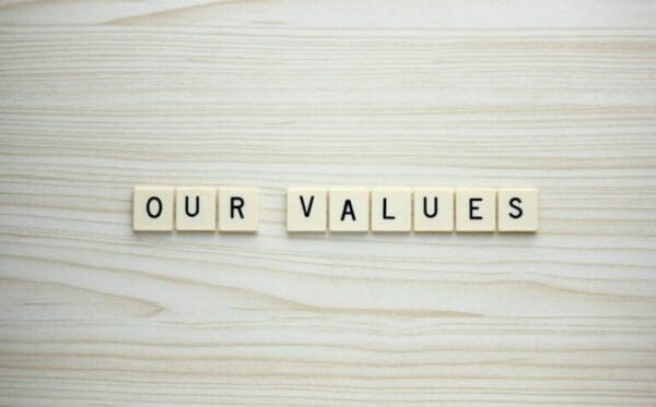 Our Values letter tiles on a wood grain background